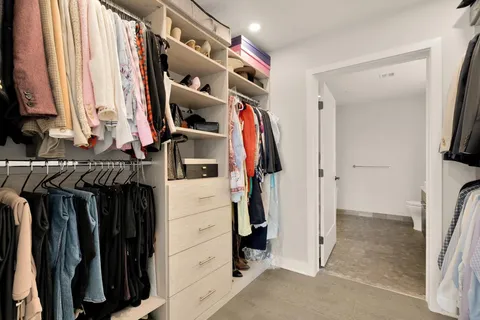 a view of walk in closet with clothes and shoes