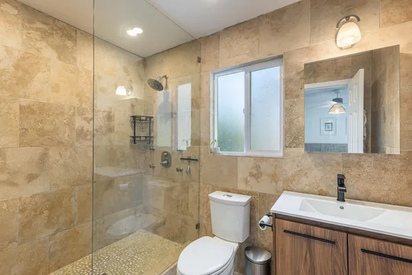 a bathroom with a sink toilet a mirror and shower
