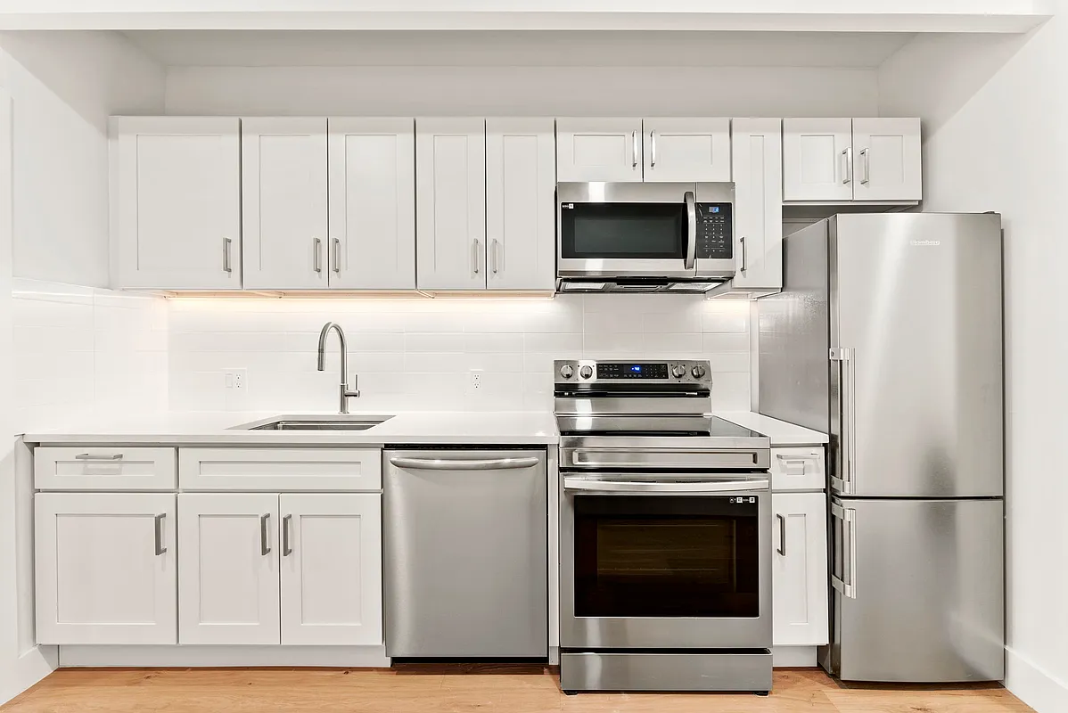 88 5th Avenue, Unit 4L Brooklyn, NY 11217 - Photo 3 of 5 a kitchen with white cabinets and stainless steel appliances
