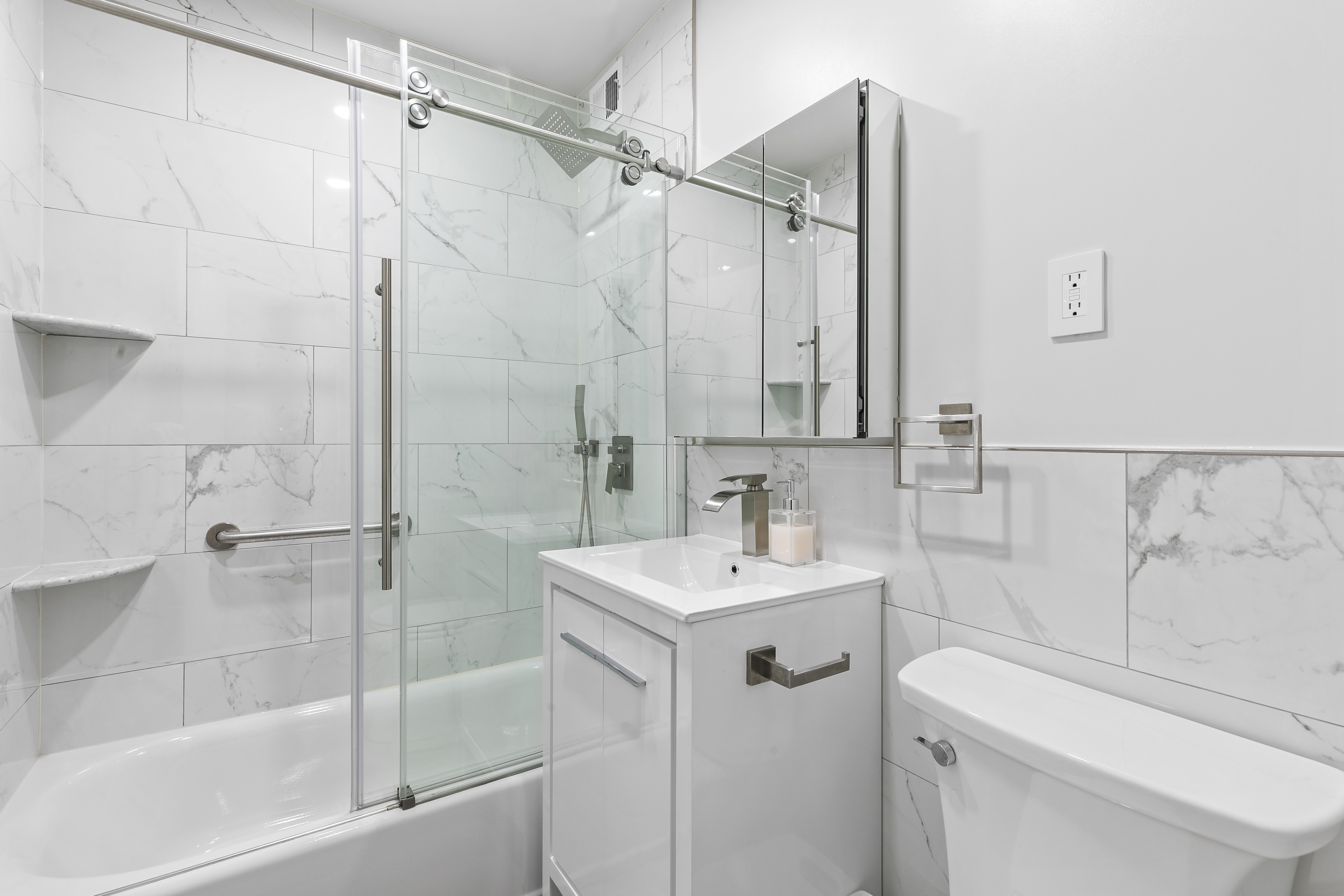 9201 Shore Road, Unit B301 Brooklyn, NY 11209 - Photo 4 of 12 a bathroom with a sink toilet vanity and shower