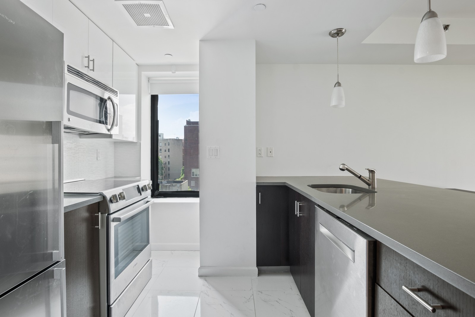 189 Avenue C, Unit 6A Manhattan, NY 10009 - Photo 3 of 10 a kitchen with stainless steel appliances granite countertop a stove and a refrigerator