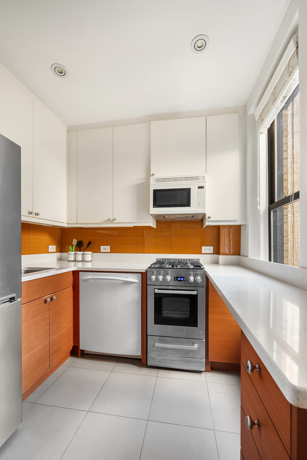 319 West 18th Street, Unit 4H Manhattan, NY 10011 - Photo 4 of 6 a kitchen with stainless steel appliances granite countertop a stove a sink and a microwave