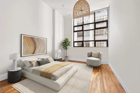 a spacious bedroom with a bed and a window