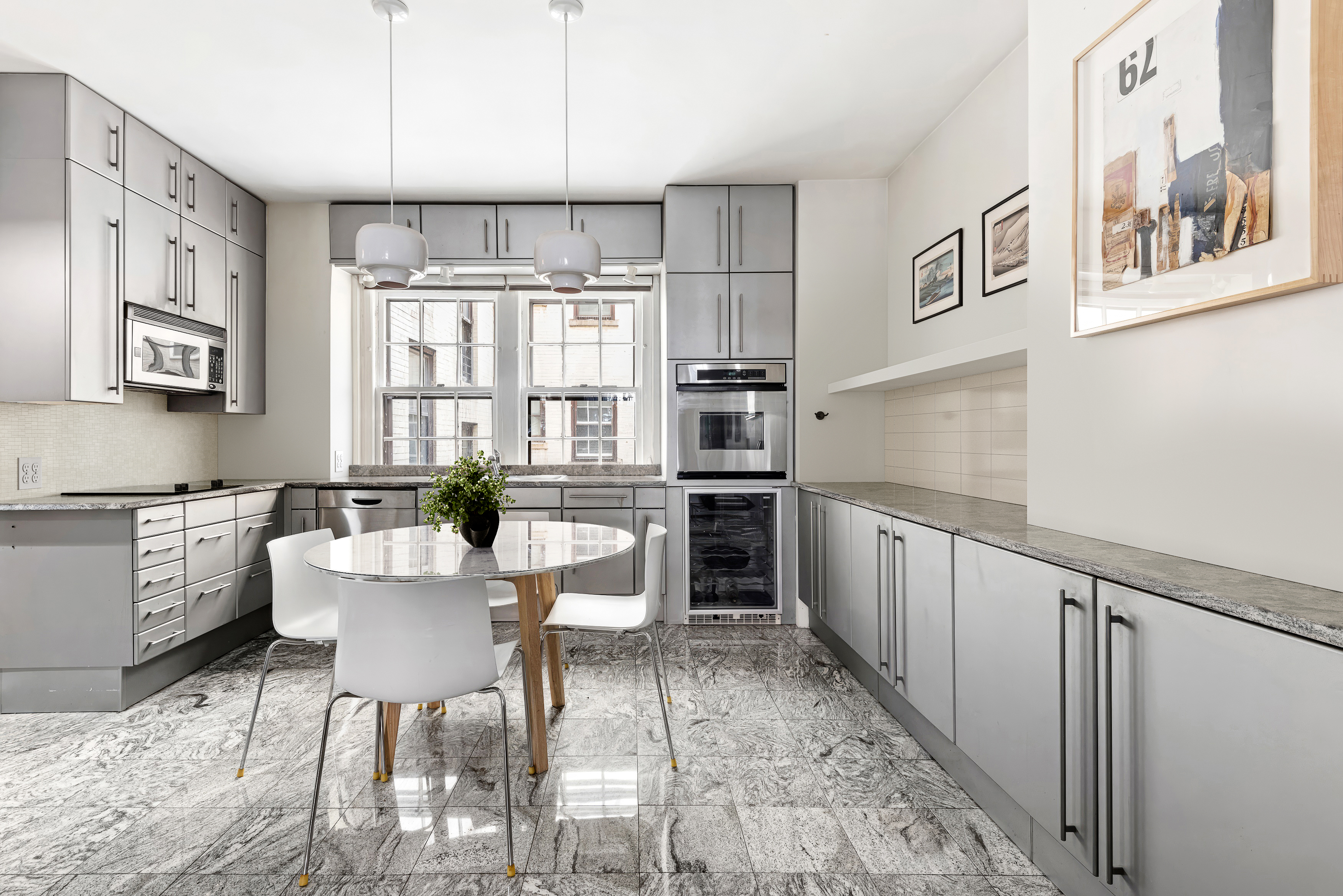 24 Monroe Place, Unit MD Brooklyn, NY 11201 - Photo 2 of 9 a kitchen with a dining table chairs and cabinets