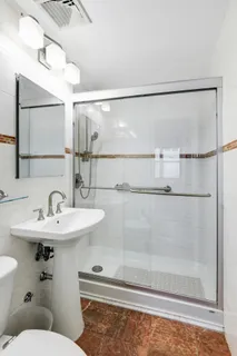 a bathroom with a sink mirror and toilet