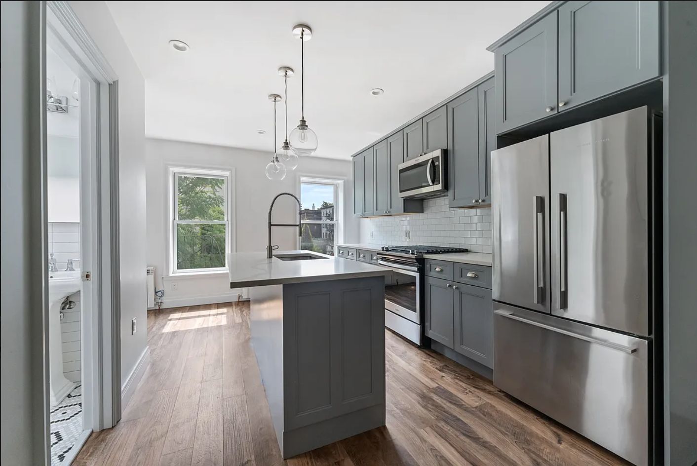 a kitchen with stainless steel appliances a refrigerator sink and microwave