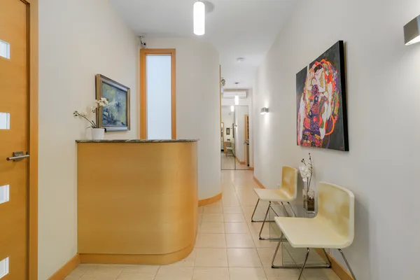 a living room with furniture and a refrigerator