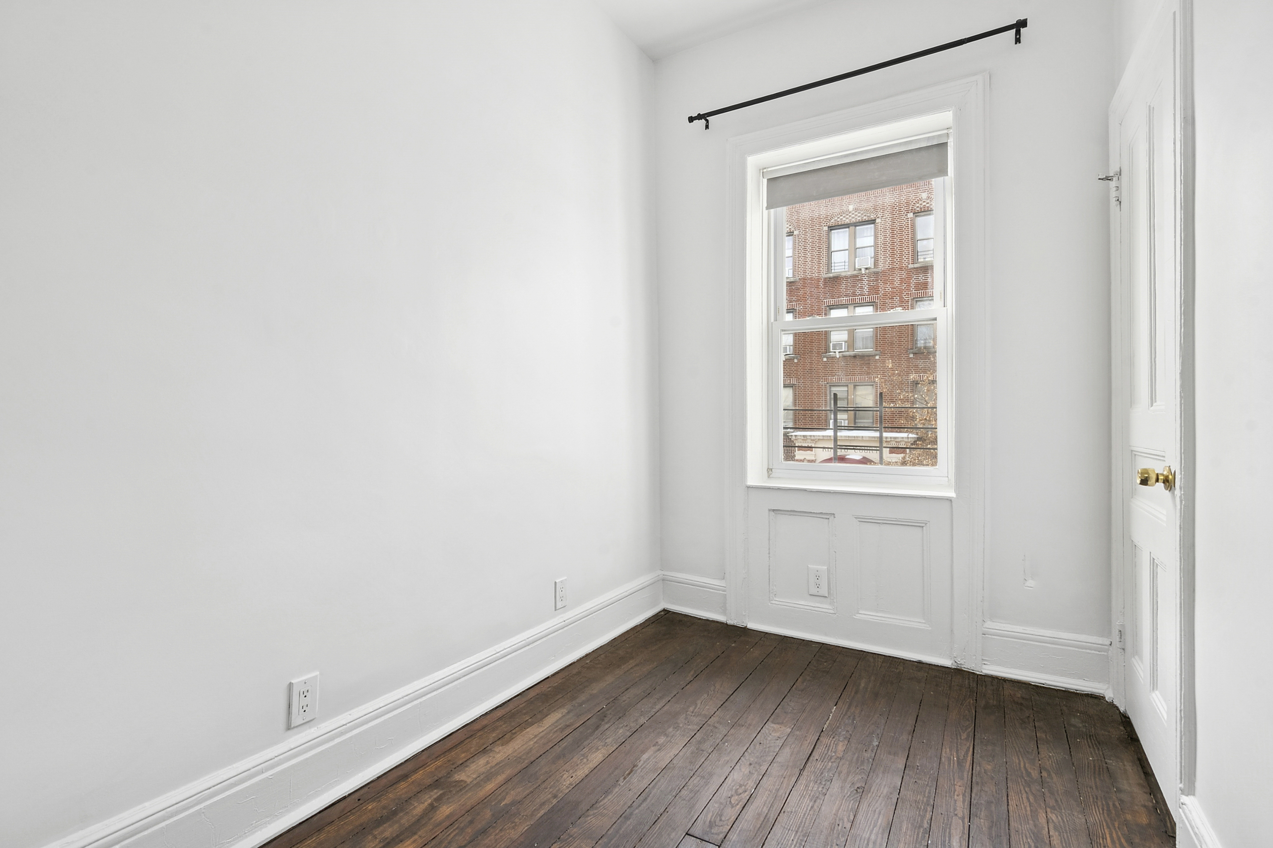 239 East 23rd Street, Unit 2 Brooklyn, NY 11226 - Photo 7 of 8 a view of an empty room with wooden floor and a window