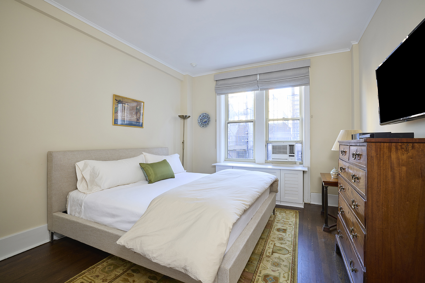 161 East 79th Street, Unit 7B Manhattan, NY 10075 - Photo 11 of 15 a bedroom with a bed a flat screen tv and a window