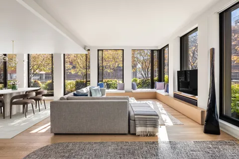 a living room with large windows and a rug