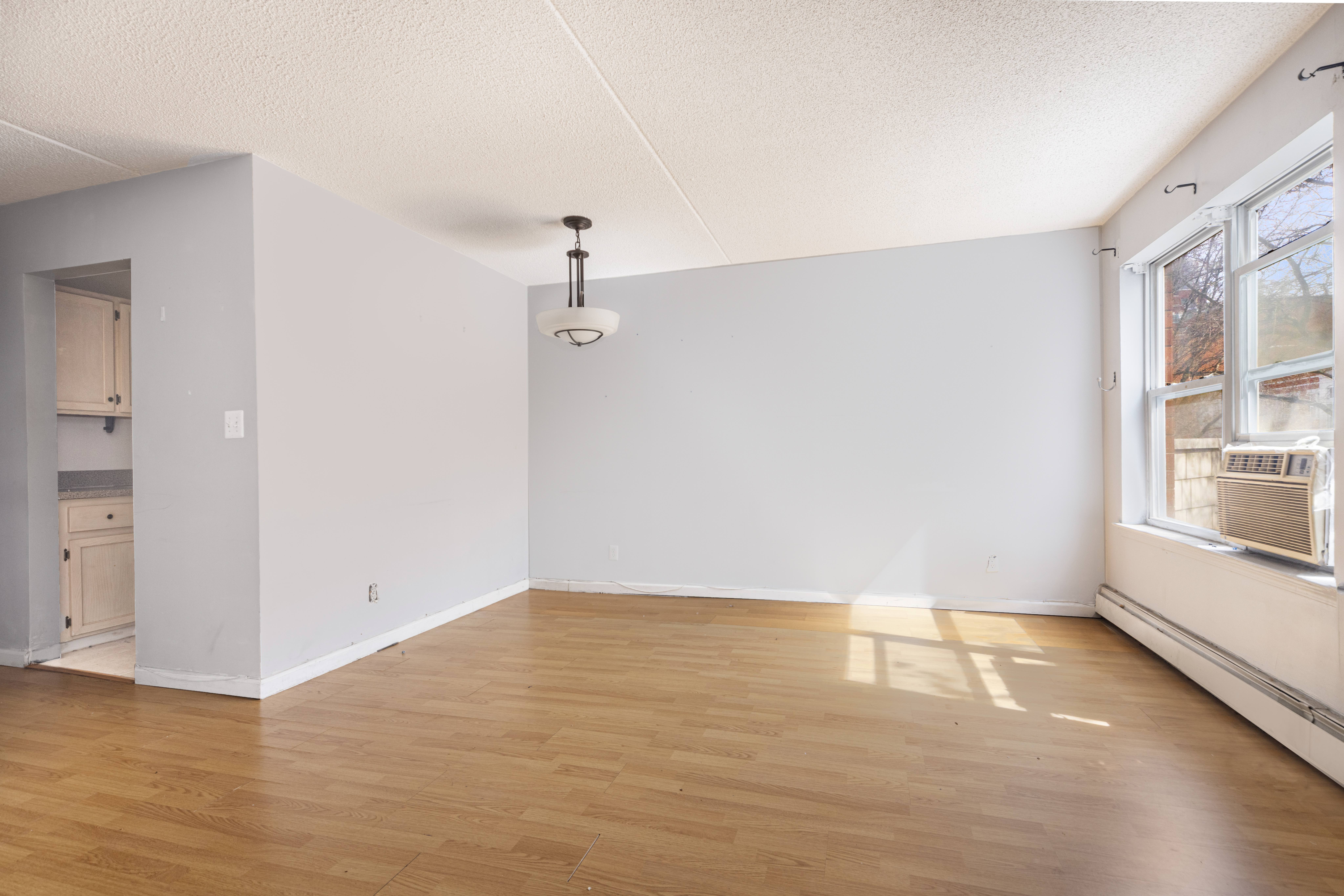 125 West 117th Street Manhattan, NY 10026 - Photo 11 of 23 wooden floor in an empty room with a window