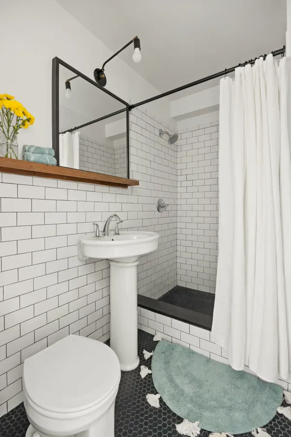 a bathroom with a sink a toilet and shower