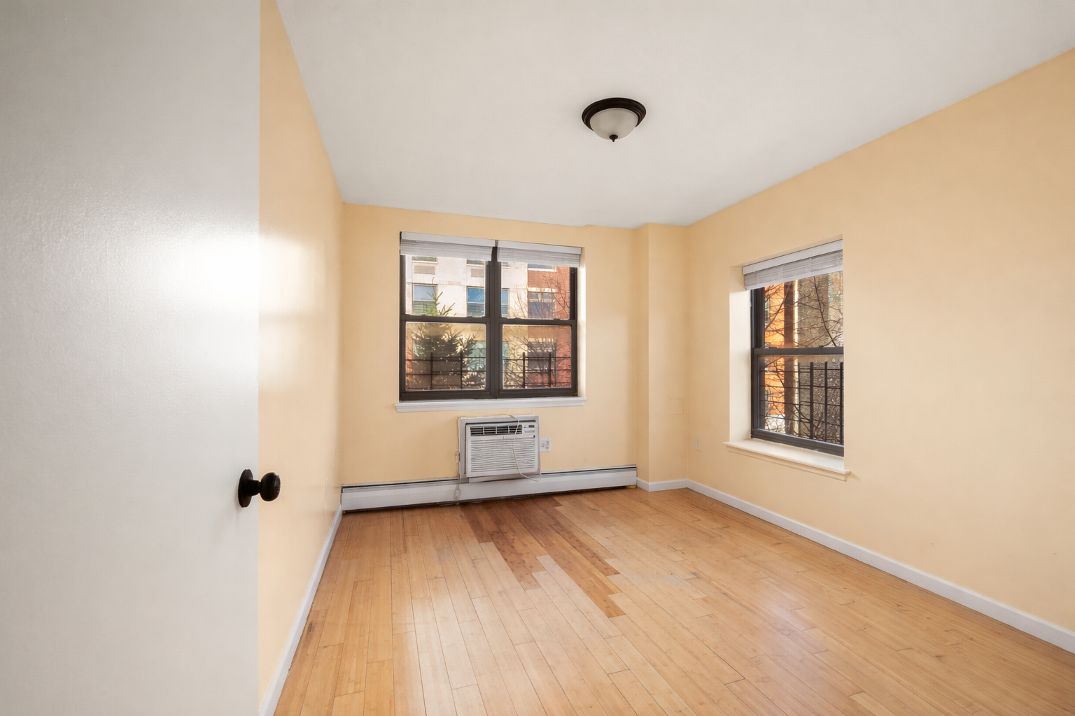 415 East 160th Street, Unit 3 Bronx, NY 10451 - Photo 6 of 10 an empty room with wooden floor and windows