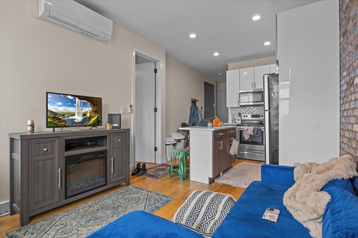 34 Rockaway Avenue Brooklyn, NY 11233 - Photo 3 of 9 a living room with furniture and a flat screen tv