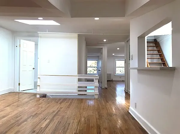 a view of empty room with wooden floor