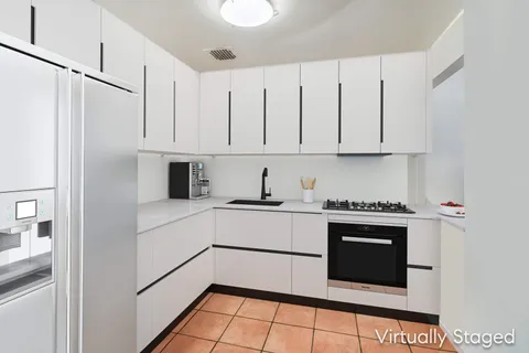a kitchen with stainless steel appliances granite countertop a stove a refrigerator and white cabinets