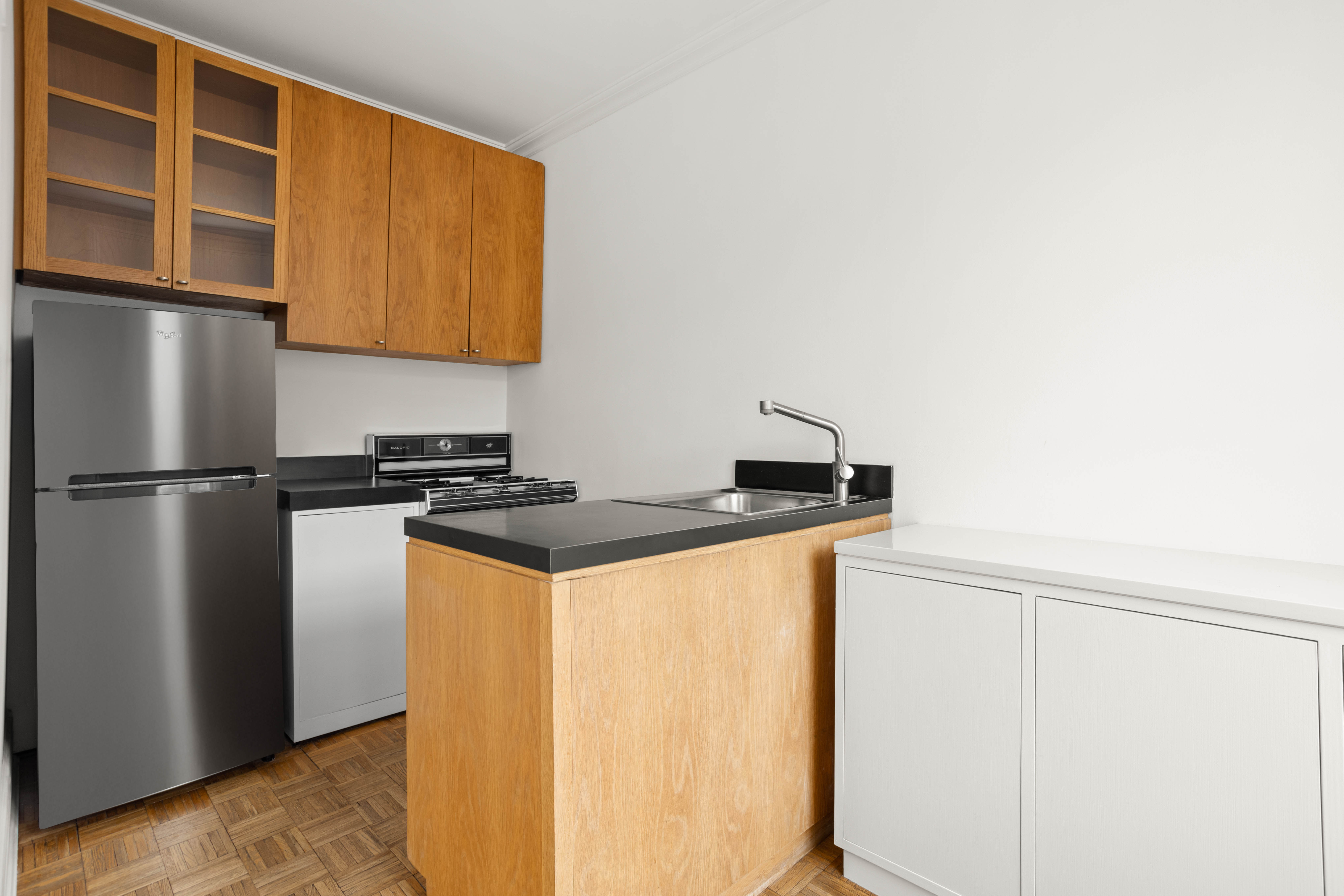 357 West 20th Street, Unit B Manhattan, NY 10011 - Photo 9 of 10 a kitchen with stainless steel appliances granite countertop a refrigerator a stove and a sink with wooden floor