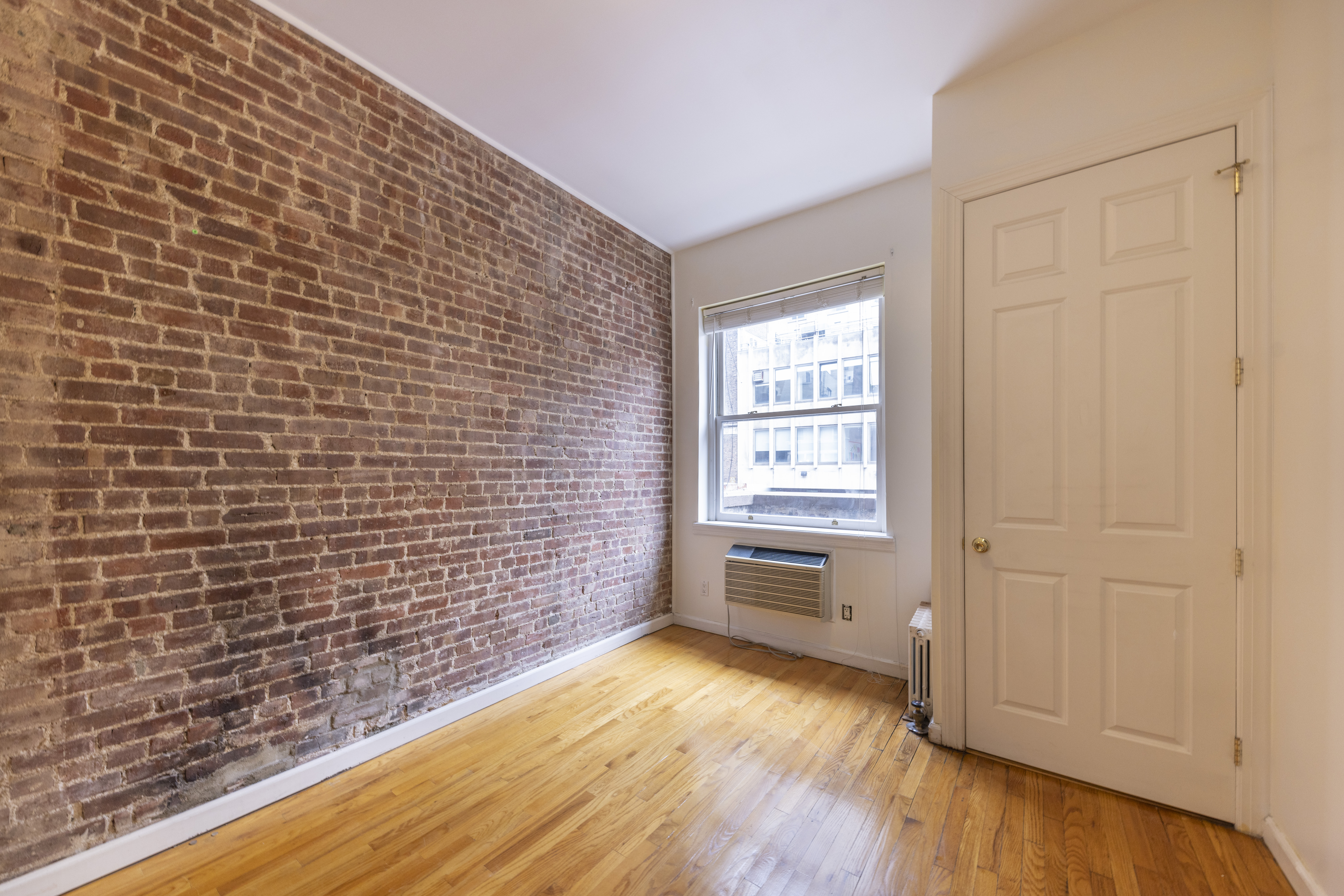 1384 Lexington Avenue, Unit 2 Manhattan, NY 10128 - Photo 5 of 11 a bathroom with a wooden floor and a window