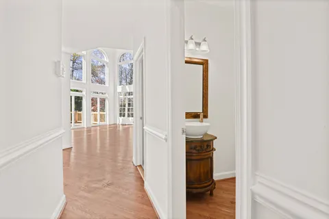 a view of a hallway with wooden floor and closet