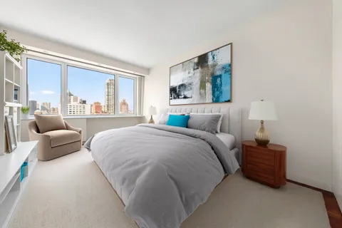 a bedroom with a bed couch and a large window