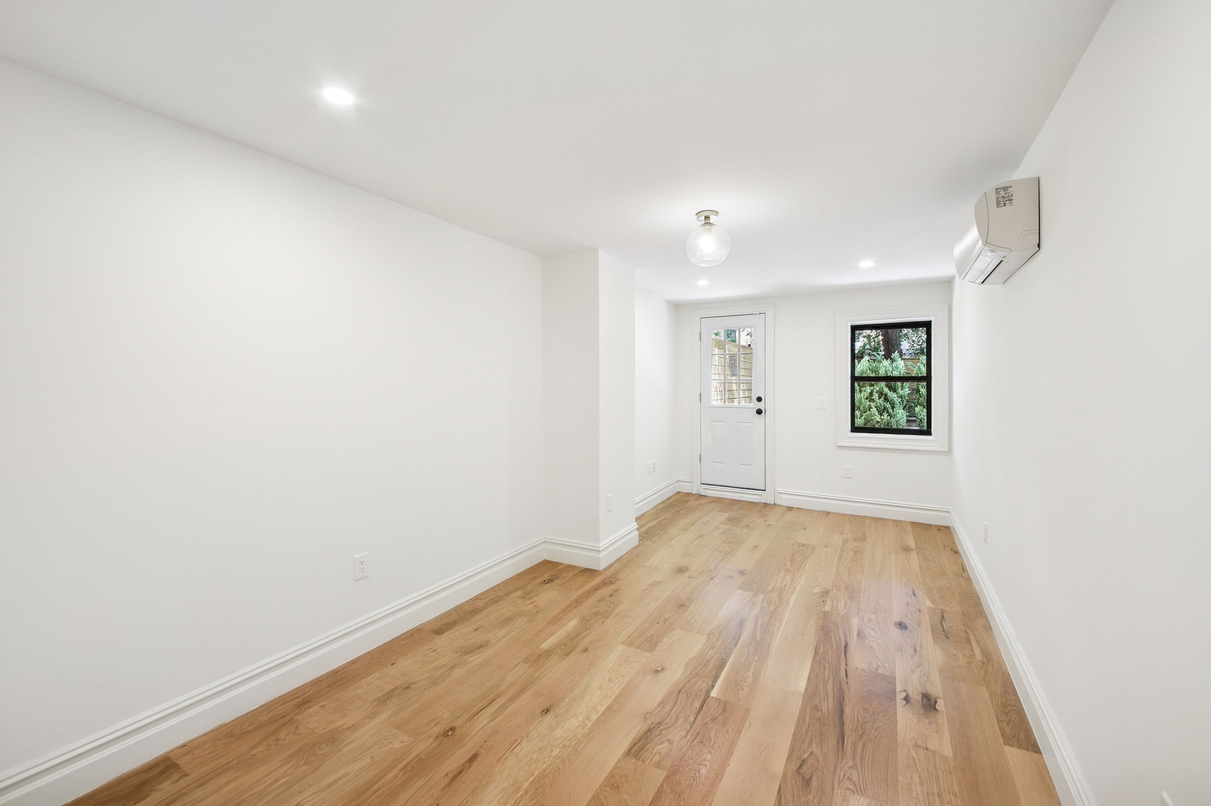 239 Madison Street, Unit 1 Brooklyn, NY 11216 - Photo 9 of 14 an empty room with wooden floor and windows
