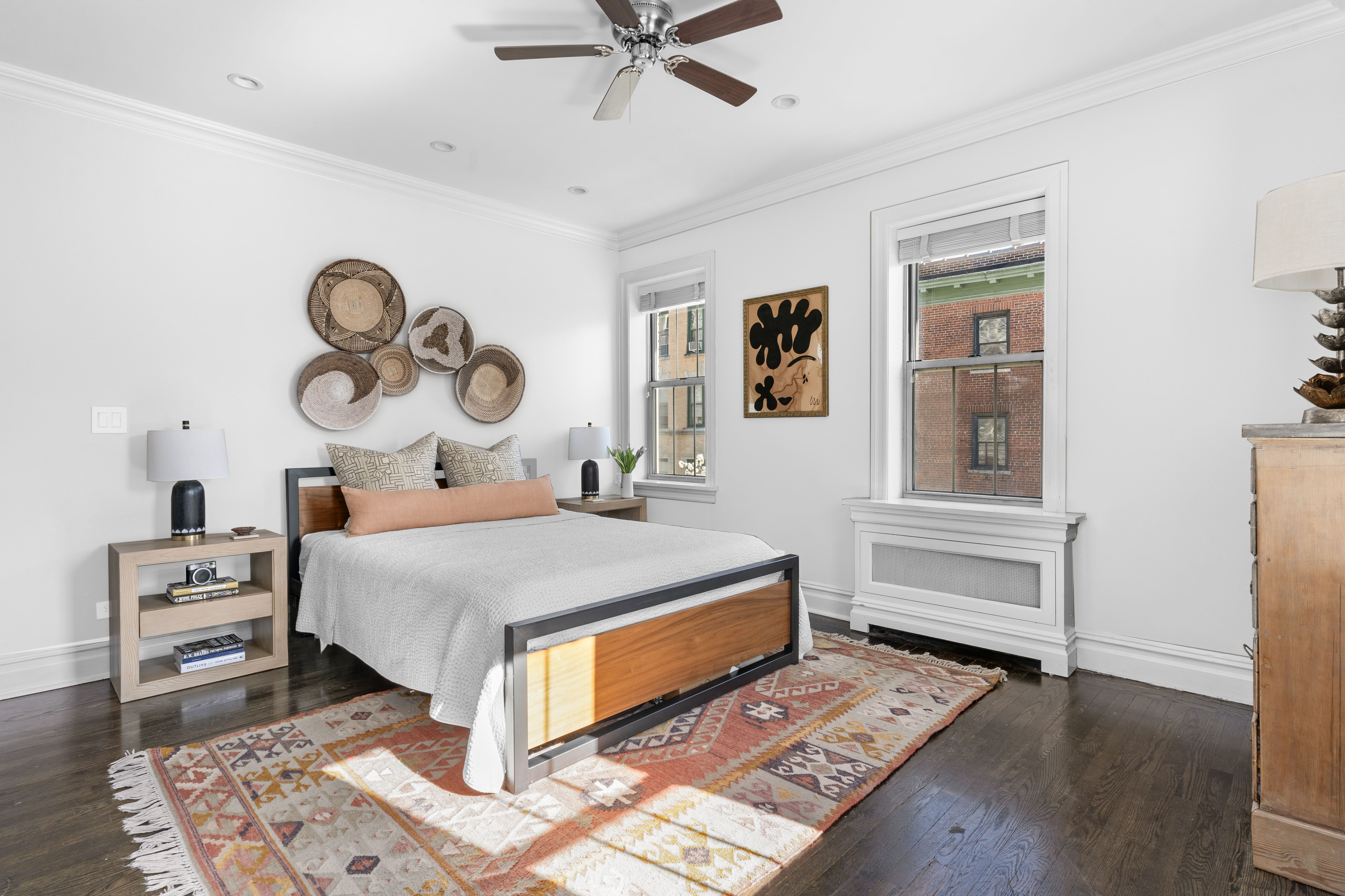 75 Bank Street, Unit 3K Manhattan, NY 10014 - Photo 7 of 11 a bedroom with a bed and dresser with wooden floor