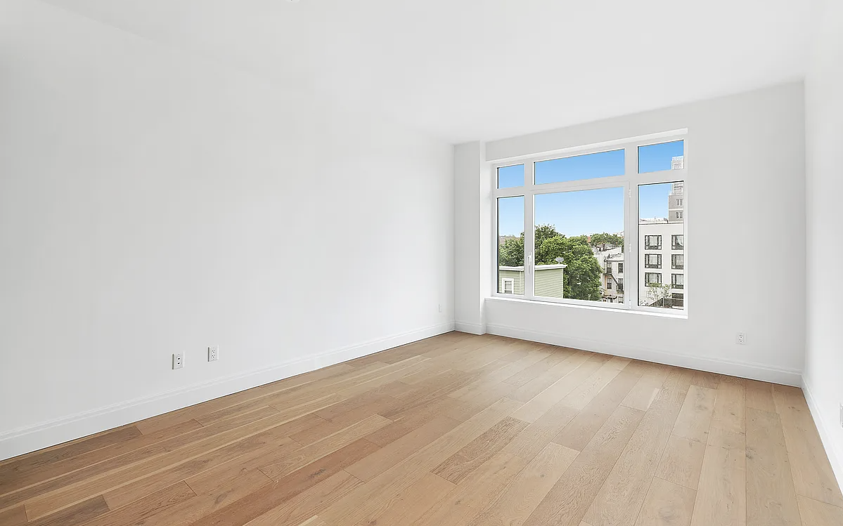181 18th Street, Unit 408 Brooklyn, NY 11215 - Photo 4 of 13 a view of an empty room with wooden floor and a window