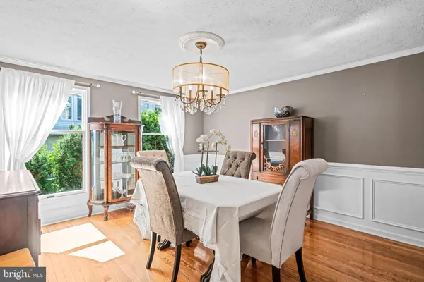 a dining room with furniture a chandelier and wooden floor