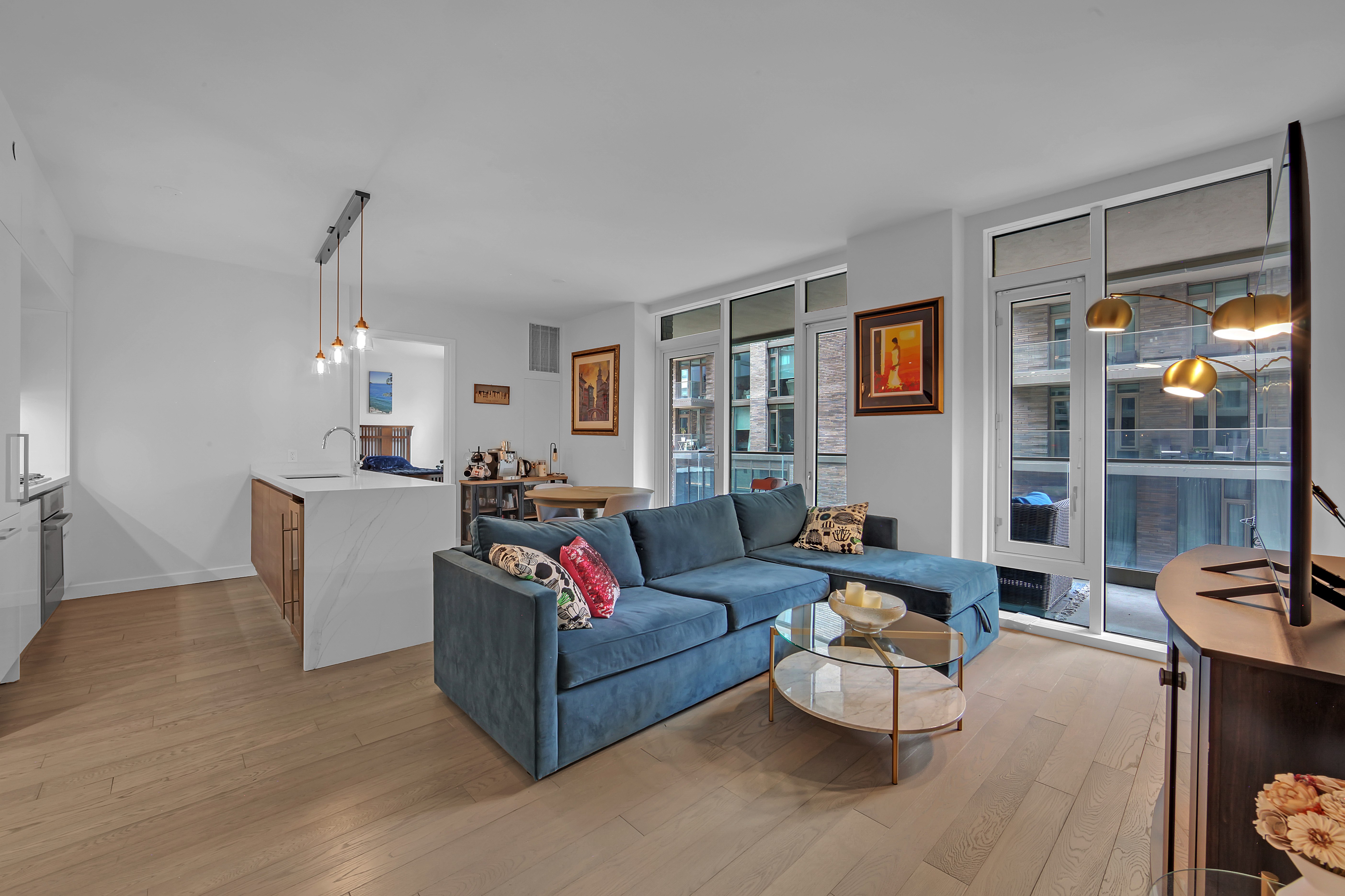 505-513 West 43rd Street, Unit 3M Manhattan, NY 10036 - Photo 2 of 20 a living room with furniture and a chandelier