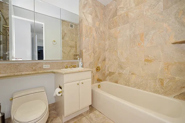 845 United Nations Plaza, Unit 56E Manhattan, NY 10017 - Photo 15 of 28 a bathroom with a sink a toilet and a bathtub