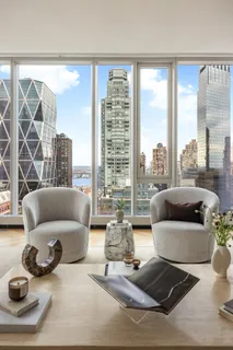 a living room with furniture and a floor to ceiling window