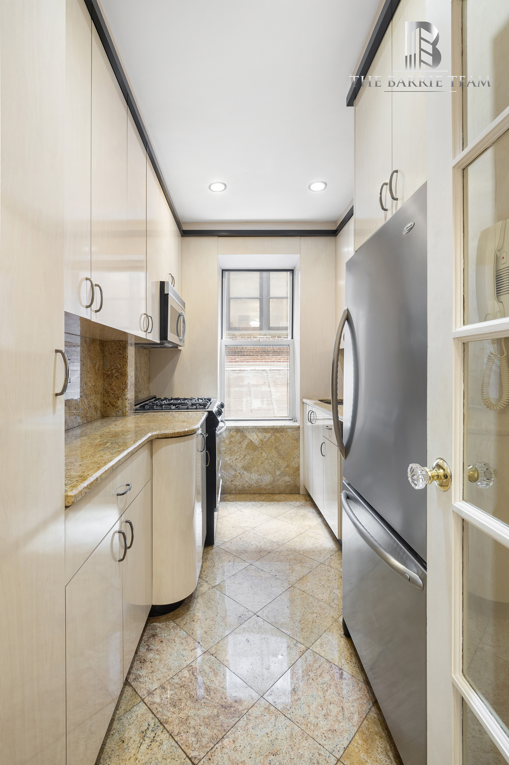 203 West 81st Street, Unit 3E Manhattan, NY 10024 - Photo 4 of 6 a kitchen with granite countertop white cabinets and white appliances