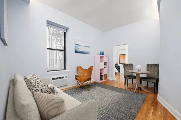 a living room with furniture wooden floor and a window