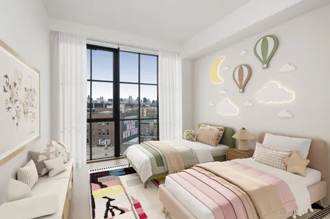 a bedroom with two beds and a large window