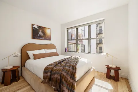 a bedroom with a bed and a large window