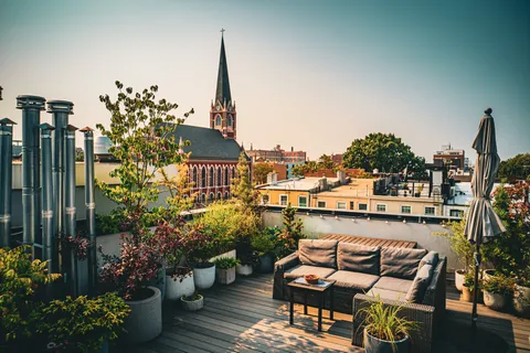 a roof deck with table and chairs potted plants
