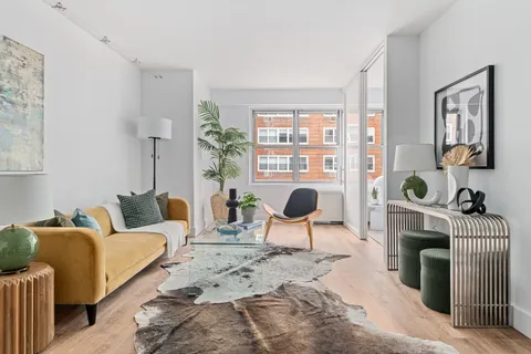 a living room with furniture a rug and white walls