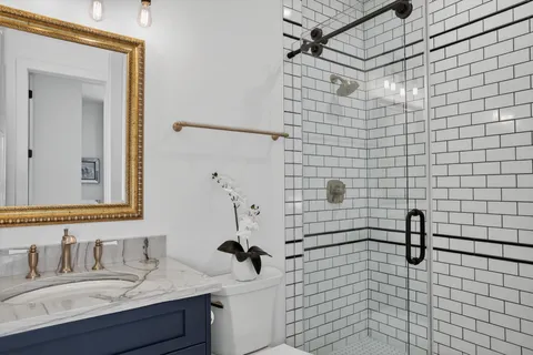 a bathroom with a sink shower and a mirror