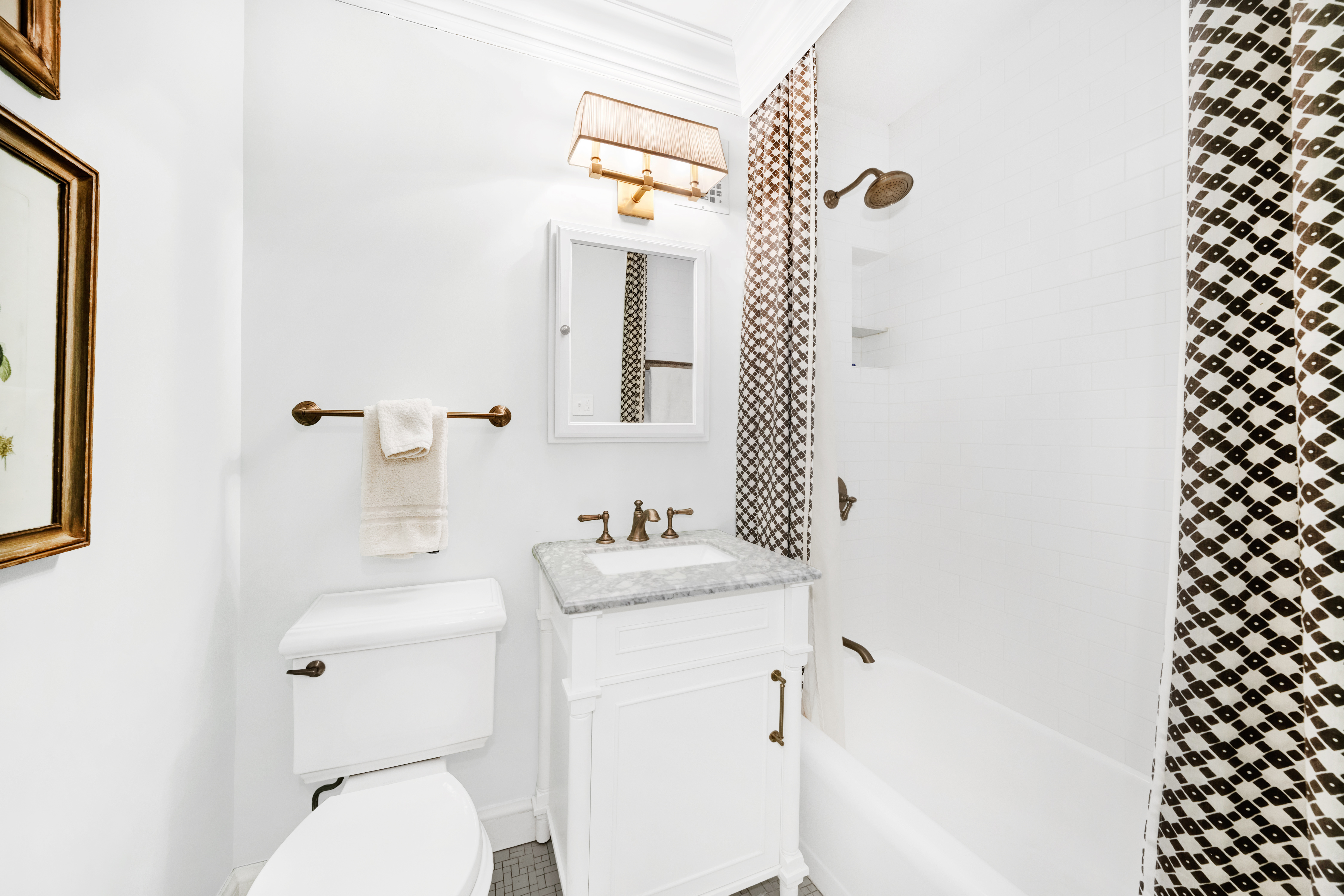 345 East 52nd Street, Unit 2C Manhattan, NY 10022 - Photo 4 of 6 a bathroom with a sink a toilet and a mirror