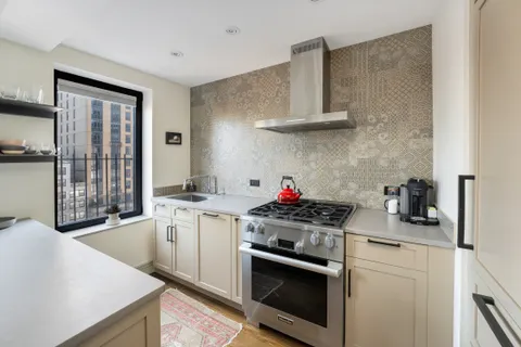 a kitchen with stainless steel appliances a sink stove and cabinets