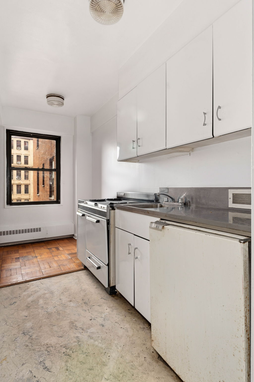 345 West 145th Street, Unit 5A1 Manhattan, NY 10032 - Photo 4 of 9 a kitchen with granite countertop white cabinets and white appliances