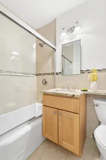 a bathroom with a granite countertop sink mirror vanity and toilet