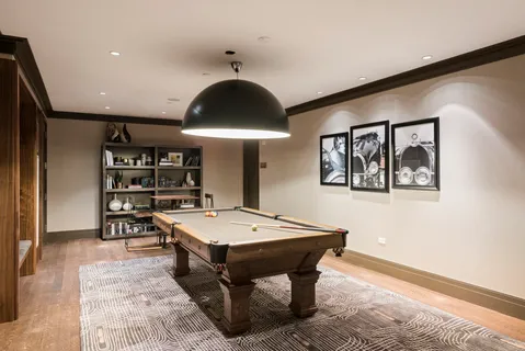 a room with pool table and wooden floor