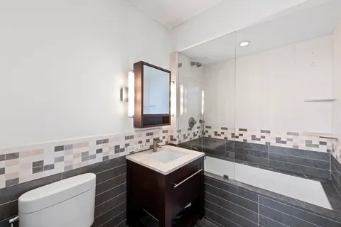a bathroom with a sink mirror and toilet
