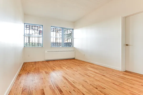 204 Huntington Street, Unit 1D Brooklyn, NY 11231 - Photo 4 of 12 a view of an empty room with wooden floor and a window