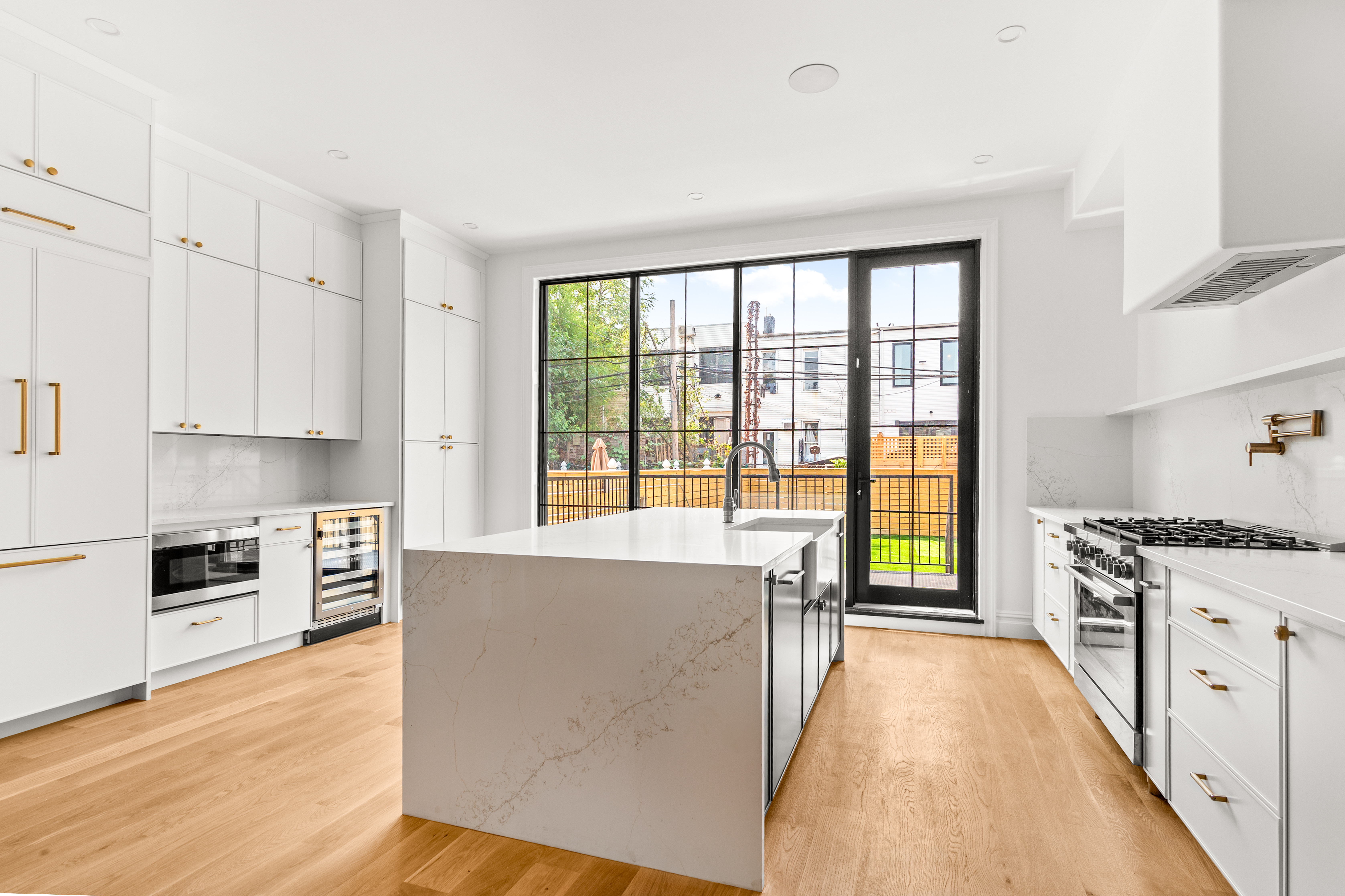 111 Harman Street Brooklyn, NY 11221 - Photo 3 of 12 a large kitchen with cabinets wooden floor and stainless steel appliances