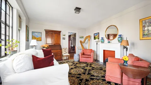 a living room with furniture a fireplace and a potted plant