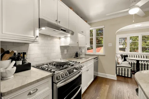 a kitchen with stainless steel appliances a sink a stove and wooden floor