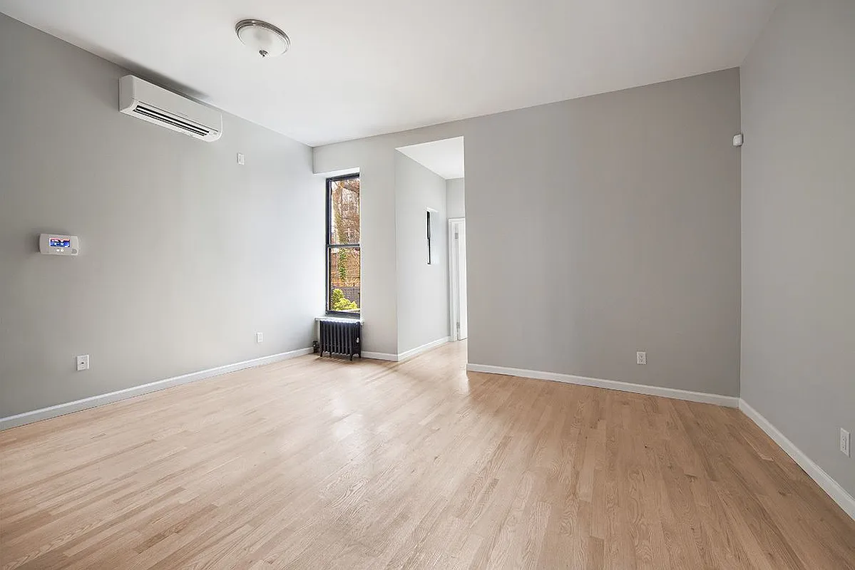 a view of an empty room with wooden floor