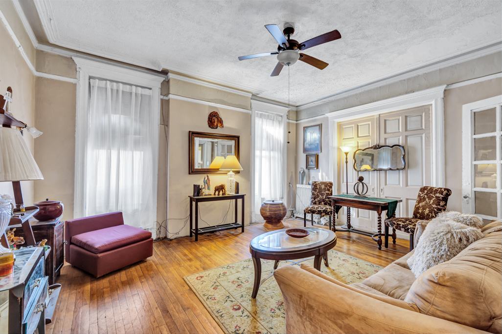 a living room with furniture a ceiling fan and a window